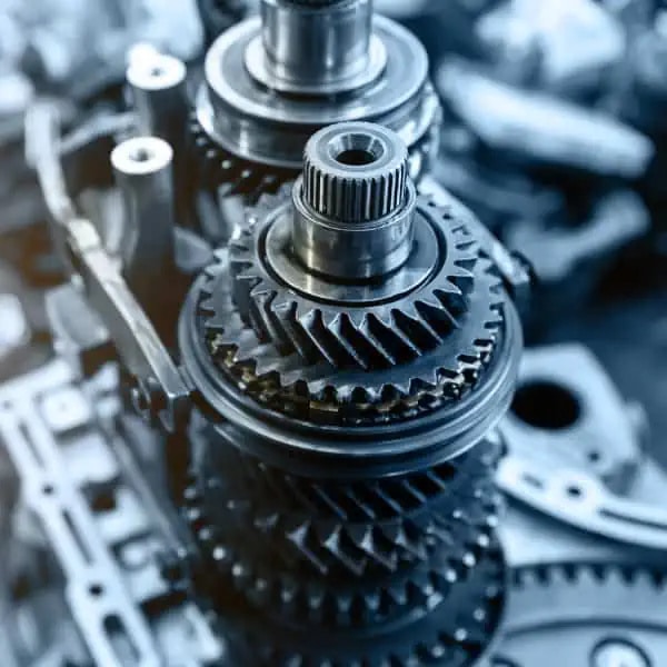Close-up view of metal gears and shafts in a mechanical gearbox assembly.