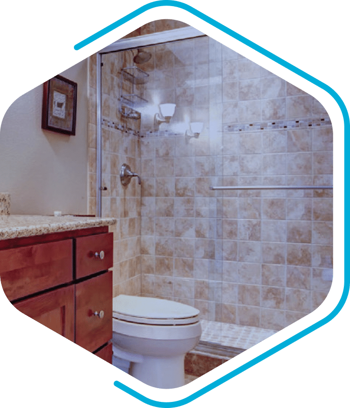 A bathroom with a glass-enclosed, tiled shower, a toilet, wooden cabinets, and a granite countertop.
