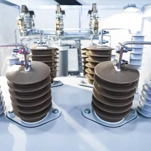 Close-up view of high-voltage electrical insulators and connectors inside an industrial power distribution equipment.