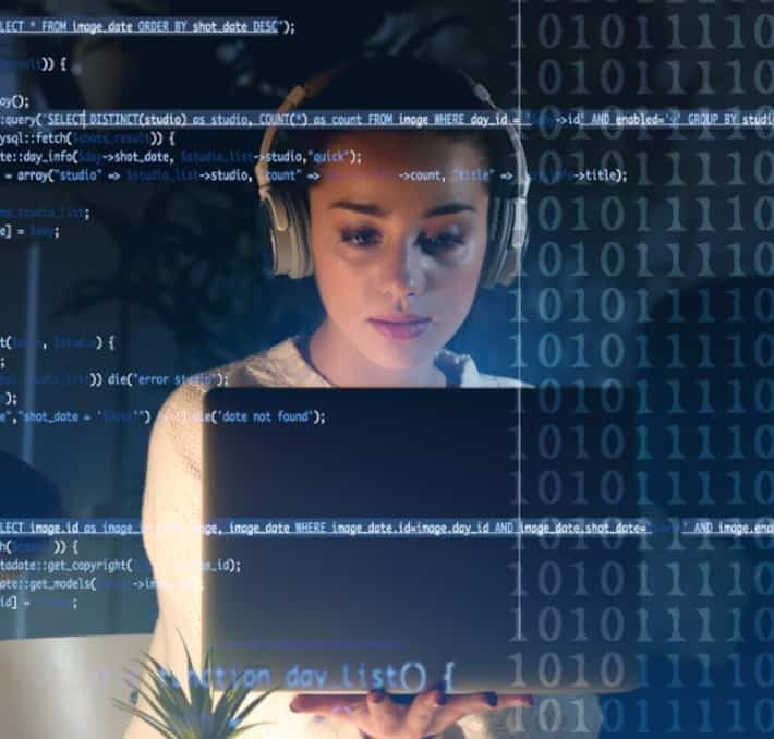 A woman wearing headphones looks at a laptop screen, with transparent code and binary numbers overlaid in the foreground.