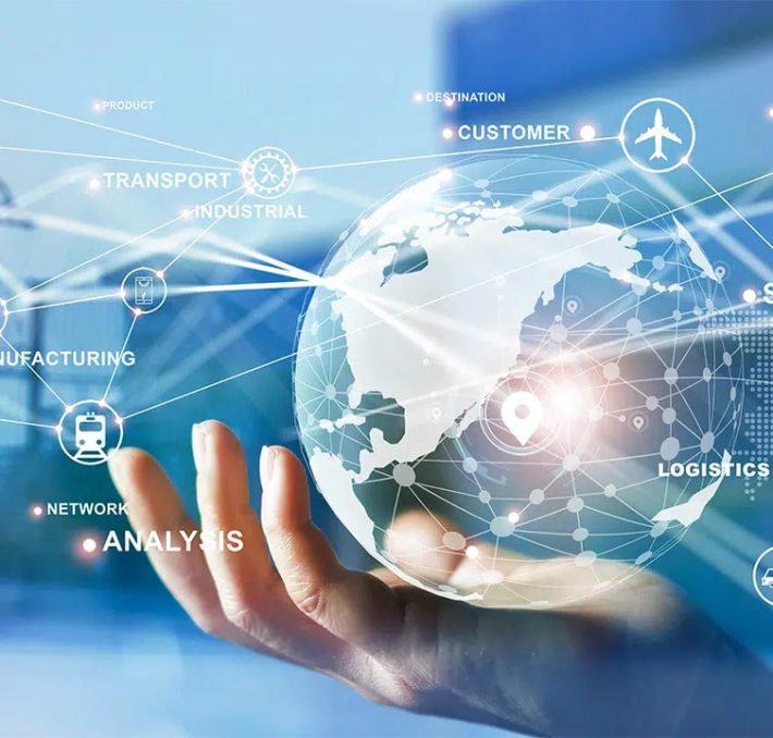 A hand holds a digital globe with overlaid icons and labels for concepts like logistics, analysis, transport, and manufacturing, representing global connectivity and technology.